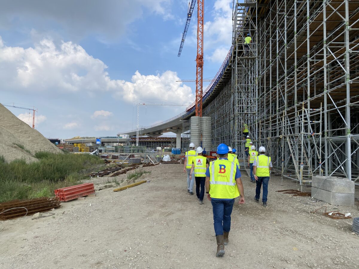 Des personnes marchent le long des échafaudages et d’un ouvrage en béton sur le chantier de THV Civiel Linkeroever.
