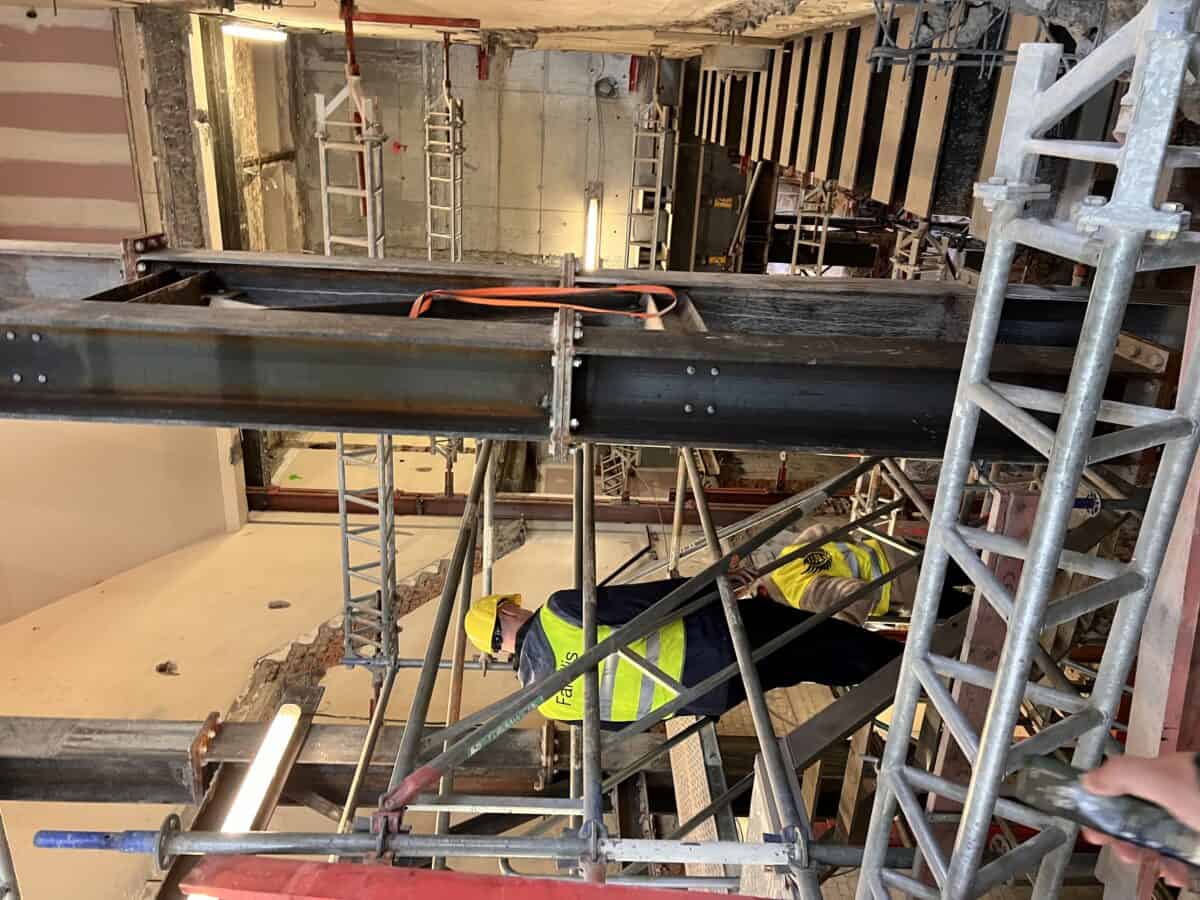 Werfbezoek tussen de tijdelijke staalconstructies en stellingen van de metrowerf in Brussel.